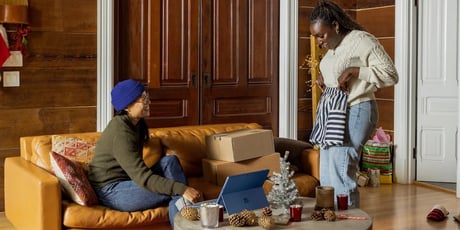 two women showing each other their peak season shopping 